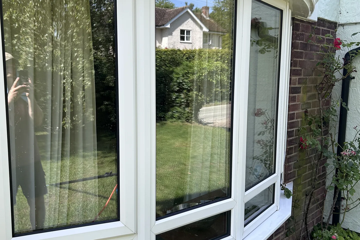 A cleaned bow window on a brick house